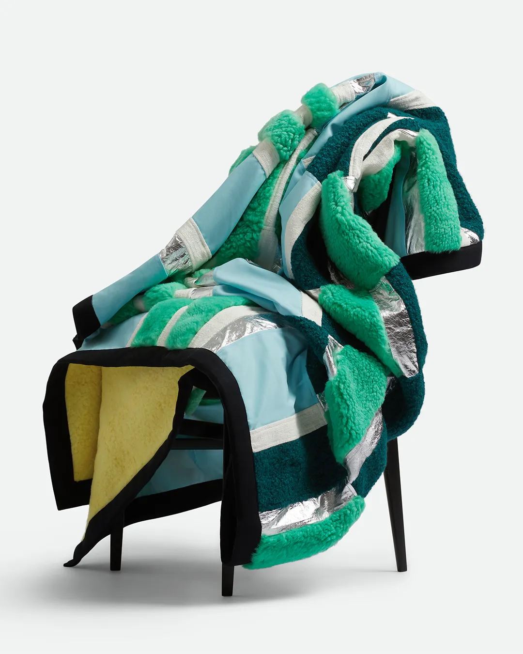 Colorful Bottega Veneta fabric and shearling textile display on black chair