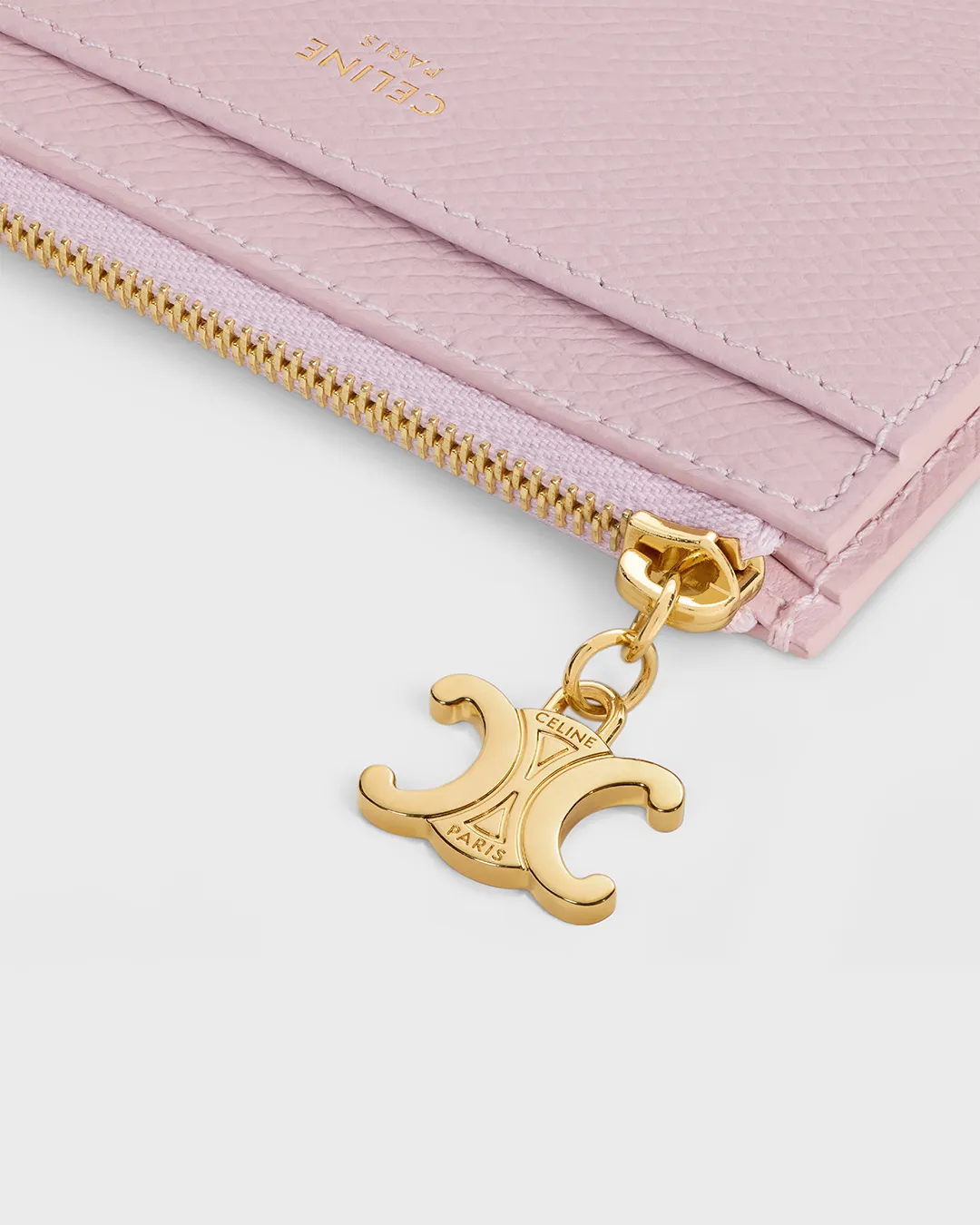 Celine pink leather wallet with gold zipper and logo charm displayed in portfolio image