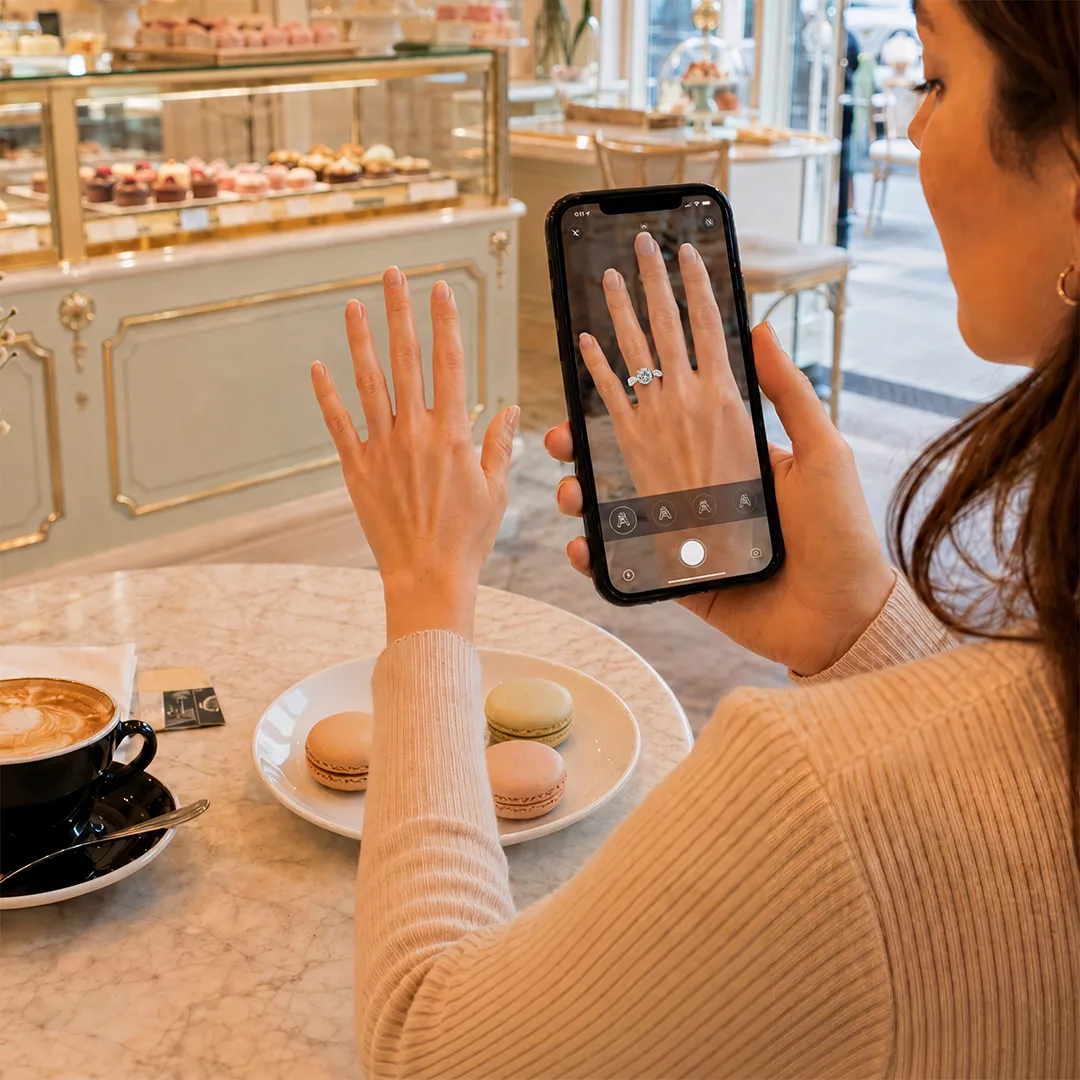 Customer using AR technology on a smartphone to virtually try on a ring through an immersive XR shopping experience